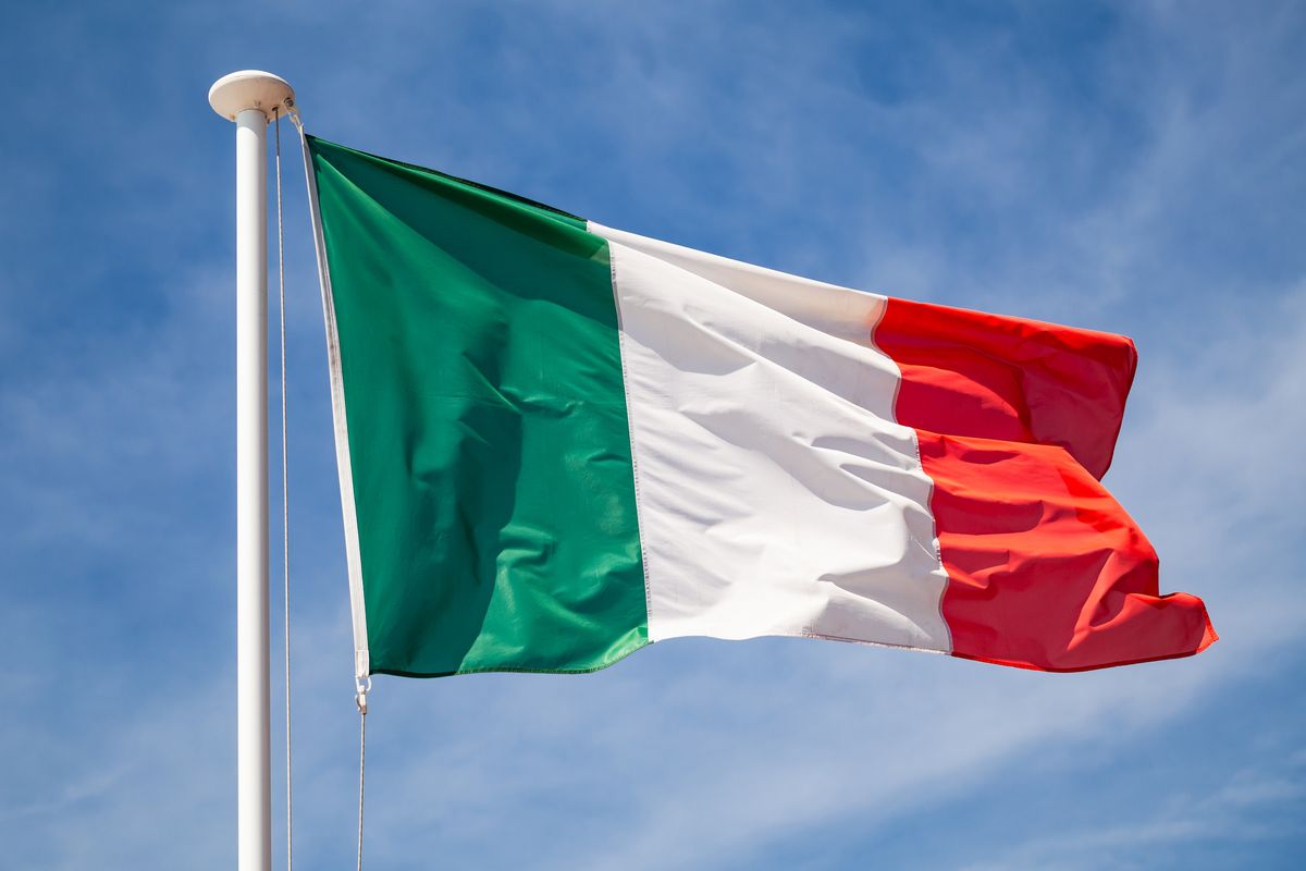 Bandiera italiana sull'asta, contro il cielo azzurro